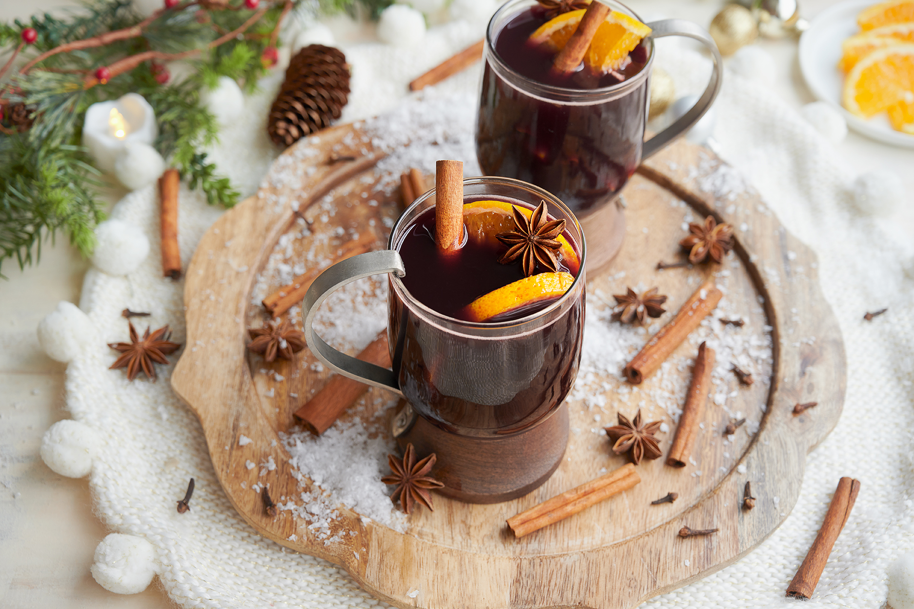 two mugs of mulled wine with holiday decor