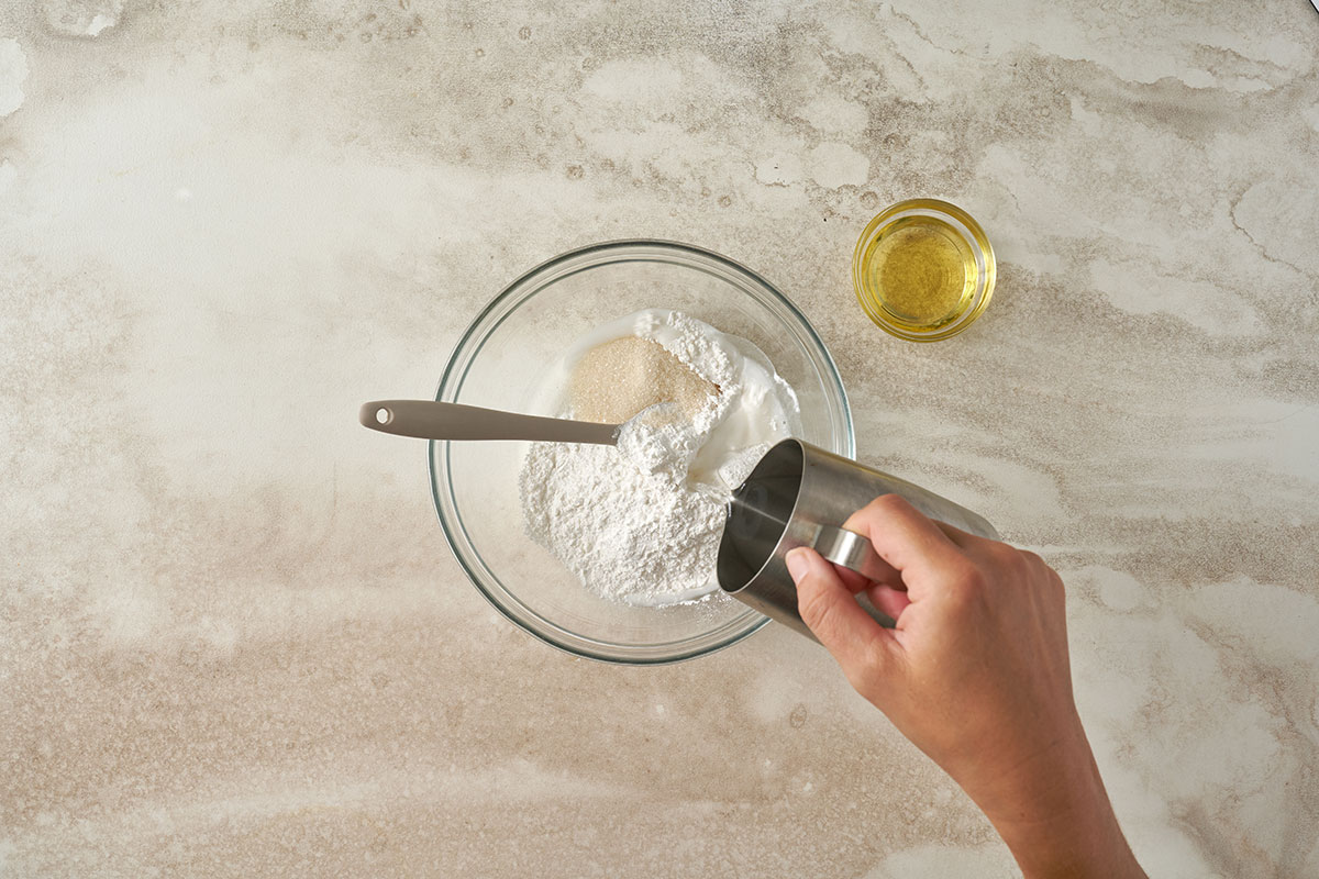 Mixing glutinous rice flour and sugar, and adding hot water to create a smooth dough for Pumpkin Sesame Balls, by Pacific Spice.