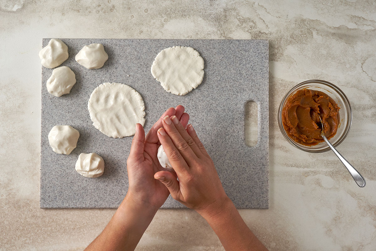 Flattening dough, adding pumpkin filling, and shaping it into balls for Pumpkin Sesame Balls, by Pacific Spice.